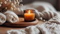 Close up of Burning candle in small amber glass jar on wooden plate - Cozy lifestyle concept