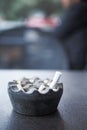 Close up burning cigarette in ashtray on table