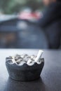 Close up burning cigarette in ashtray on table Royalty Free Stock Photo