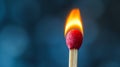 Close-up of a burning match against a blue bokeh background. Royalty Free Stock Photo