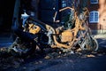 Close up of burnt out moped on street of London on sunny day with winter