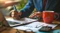 close-up of a business analytics workspace which includes a person analyzing a financial graph with a pen in hand.. AI Royalty Free Stock Photo