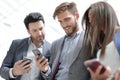 Close up.business colleagues reading a text on smartphones Royalty Free Stock Photo