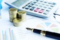 Close up of Business fountain pen and coins stack and calculator on document chart backgrounds Royalty Free Stock Photo