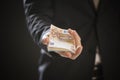 Close up of a business man hands offering money.