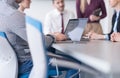 close up of business man hands typing on laptop with team on meeting in background Royalty Free Stock Photo