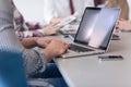 close up of business man hands typing on laptop with team on meeting in background Royalty Free Stock Photo