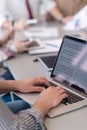 close up of business man hands typing on laptop with team on meeting in background Royalty Free Stock Photo