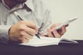 Close up of business man holding a pen and writing research note Royalty Free Stock Photo