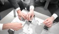 Close up.business partners putting together a puzzle ,sitting at office Desk Royalty Free Stock Photo