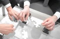 Close up.business partners putting together a puzzle ,sitting at office Desk Royalty Free Stock Photo