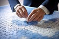 Close up of business people hands assembling jigsaw puzzle with missing piece