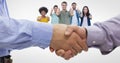 Close-up of business people shaking hands while colleagues gesturing thumbs up Royalty Free Stock Photo