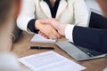 Close up of business people shaking hands at meeting or negotiation in the office. Partners are satisfied because