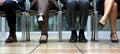 Close up of business peoples legs waiting for a job interview. Hiring and recruitment concept