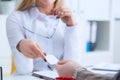 Close-up of business woman hand giving visiting card to male colleague at desk in office. First meeting between a lawyer Royalty Free Stock Photo