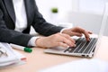 Close up of business woman hands typing on laptop computer in the white colored office. Royalty Free Stock Photo