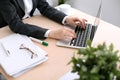 Close up of business woman hands typing on laptop computer in the white colored office Royalty Free Stock Photo