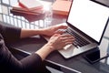 Close-up of business woman hands using working on laptop at co-working open space loft, mobile smartphone, metallic cold interior. Royalty Free Stock Photo