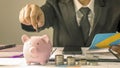 Close-up of a business woman putting money in a piggy bank, money saving ideas. Royalty Free Stock Photo