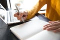 Close up of business woman`s hands using laptop and writing in notepad.