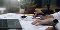 Close up Business woman using calculator and laptop for do math finance on wooden desk in office and business working background, Royalty Free Stock Photo