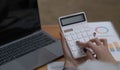 Close up Business woman using calculator and laptop for do math finance on wooden desk in office and business working background, Royalty Free Stock Photo