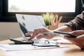 Close up Business woman using calculator and smartphone for do math finance on wooden desk in office and business working Royalty Free Stock Photo