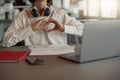 Close up of business woman working laptop while sitting in cozy cafe and showing sign love Royalty Free Stock Photo