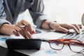 Close up of businessman or accountant hand holding pen working on calculator to calculate business data, accountancy document and Royalty Free Stock Photo