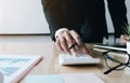 Close up of businessman or accountant hand holding pen working on calculator to calculate business data, accountancy document and Royalty Free Stock Photo