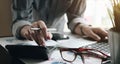 Close up of businessman or accountant hand holding pen working on calculator to calculate business data, accountancy document and Royalty Free Stock Photo