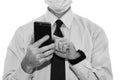 Close-up - businessman in a blue shirt and protective medical mask holds a smartphone in his hand