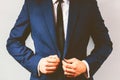 Close up of a businessman buttoning his suit.