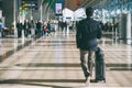 Close up of businessman carrying suitcase while walking through a passenger departure terminal in airport. Businessman traveler Royalty Free Stock Photo