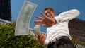 CLOSE UP: Businessman celebrates getting his first paycheck by making it rain.