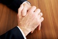 Close up of businessman clenched hands on the desk Royalty Free Stock Photo