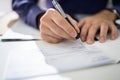 Close Up Of Businessman Filling Blank Cheque At Desk Royalty Free Stock Photo