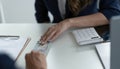 Close up of businessman hand giving money, cash dollars banknotes, to his partner on the table - loan, bribery and Royalty Free Stock Photo