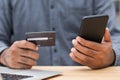 Close up businessman hand holding credit card and using smartphone and laptop computer to Financial administration. Shopping Royalty Free Stock Photo