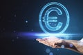 Close up of businessman hand holding glowing round euro sign on blurry blue bokeh background. Online banking, money and invest Royalty Free Stock Photo