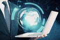 Close up of businessman hand holding laptop with glowing digital polygonal globe on blurry blue background. Technology, innovation Royalty Free Stock Photo