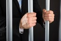 Businessman Hand Holding Metal Bars In Jail