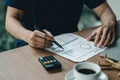 Close up businessman hand holding pen and pointing at financial paperwork, financial calculation concept Royalty Free Stock Photo