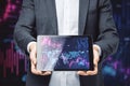 Close up of businessman hand holding tablet with downward purple forex chart on background. Crisis and recession concept