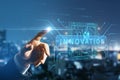 Close up of businessman hand pointing at abstract glowing innovation hologram on blurry night city background. Future and Royalty Free Stock Photo