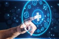 Close up of businessman hand pointing at creative round medical interface with cross and other icons on blue background. Royalty Free Stock Photo