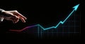 Close up of businessman hand pointing at growing graph on dark background. Business growth concept