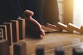 Close up of businessman hand Stopping Falling wooden Dominoes effect from continuous toppled or risk, strategy and successful int Royalty Free Stock Photo