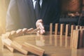 Close up of businessman hand Stopping Falling wooden Dominoes effect from continuous toppled or risk, strategy and successful int Royalty Free Stock Photo